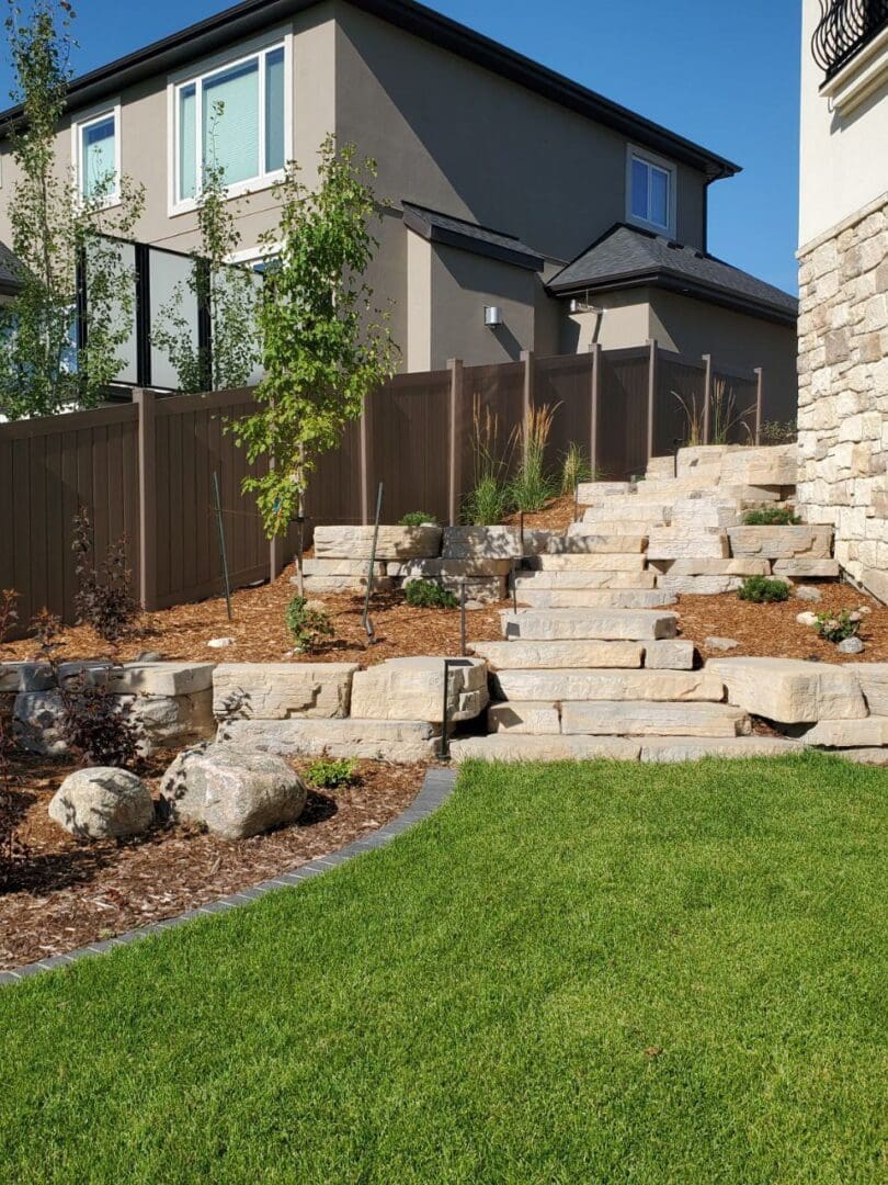 A backyard with grass and rocks in the middle of it