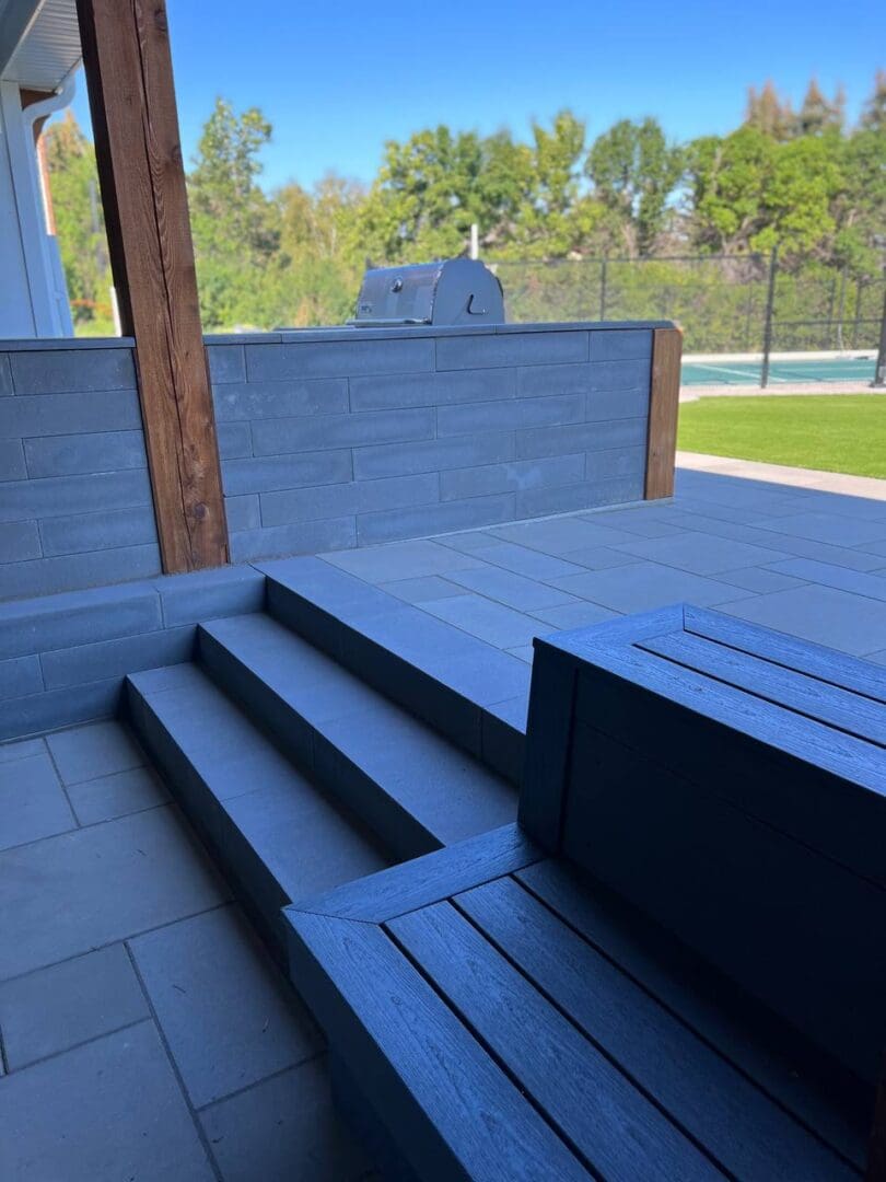 A bench and steps in the middle of a patio.