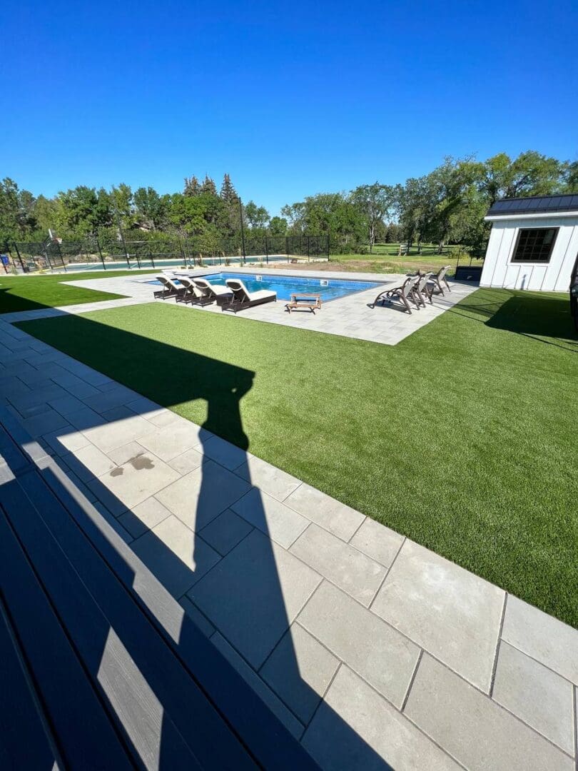 A pool with grass and a deck in the middle of it